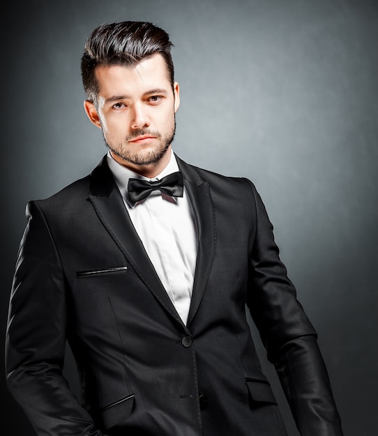 Portrait of confident handsome man in black suit with bowtie