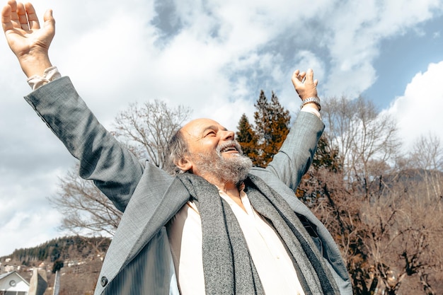 Portrait of a confident handsome mature man pensioner grandfather in the small town