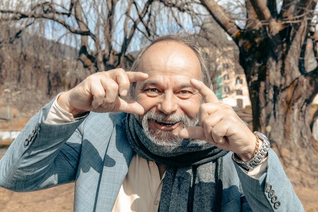 Portrait of a confident handsome mature man pensioner grandfather in the small town