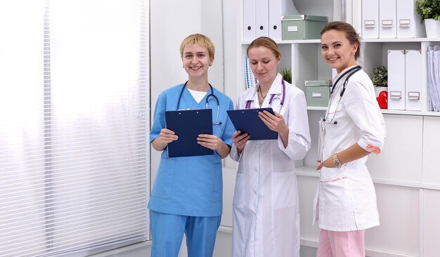 Photo portrait of confident happy group of doctors standing at the medical office