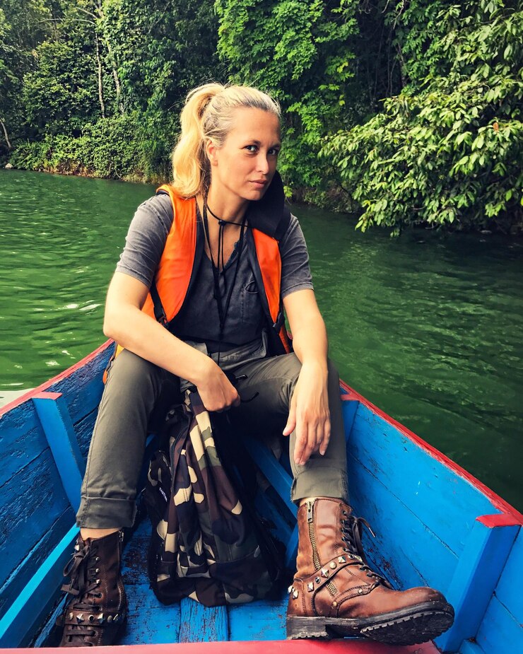 Photo portrait of confident hiker sitting in rowboat at lake