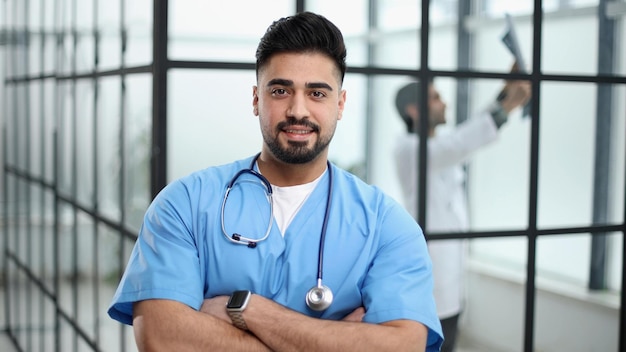 Портрет уверенного в себе мужского врача, стоящего в вестибюле больницы