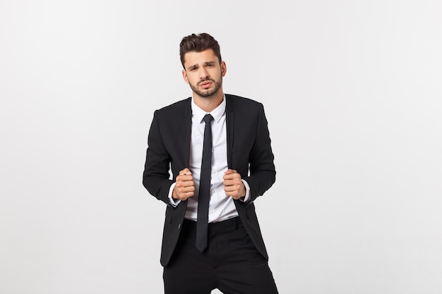 Portrait of confident mature businessman in formals standing isolated over white wall