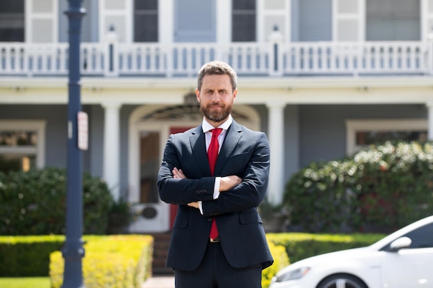 Portrait of a confident mature businessman standing outside office.