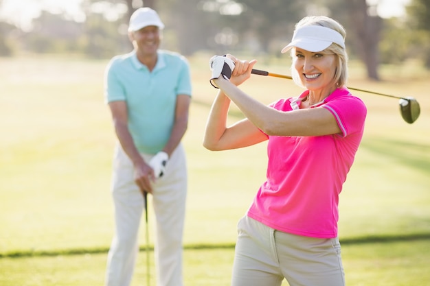 Photo portrait of confident mature woman carrying golf club by man