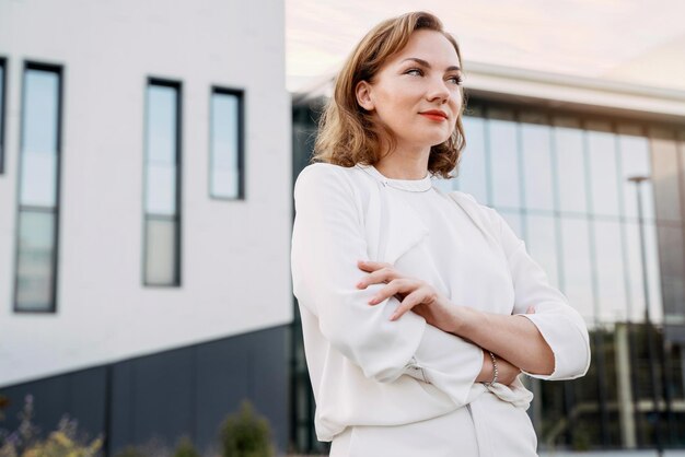 Portrait of confident middle aged businesswoman with arms crossed looking away on the street