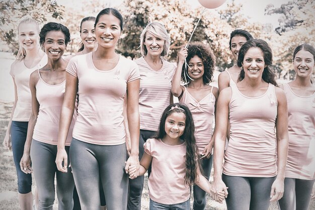 Foto ritratto di donne e ragazze multietniche sicure che sostengono la consapevolezza del cancro al seno al parco