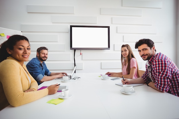 Portrait of confident partners during board meeting at creative office