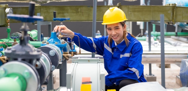 Portrait confident professional engineer woman wearing safety uniform and hard hat helmet in industrial factory workplace rooftop