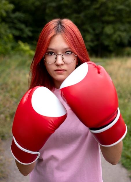 Photo portrait of confident redhead girl with boxing gloves