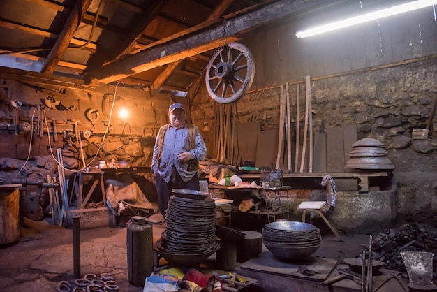 portrait of confident senior blacksmith during a break from work at traditional workshop