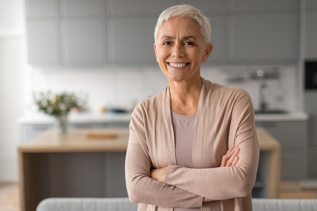 Portrait of confident senior woman with short hair crossing hands