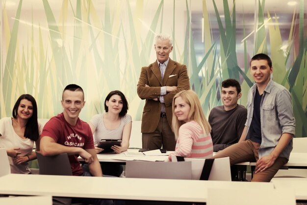 portrait of confident teacher,  students group in background