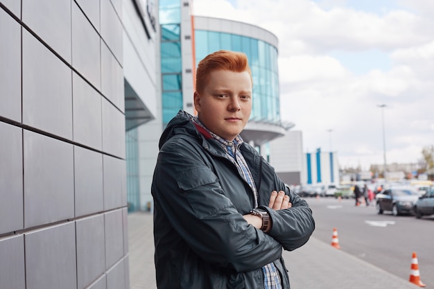 A portrait of confident teenager with red hair and stylish hairdo