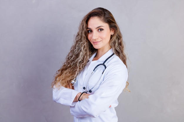 Photo portrait of confident with toothy beaming smile qualified experienced clever intelligent doctor wearing white formal wear she is standing with crossed folded arms, isolated on grey background