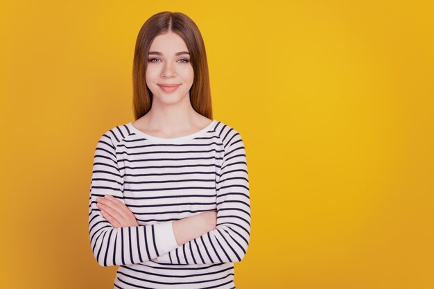 Portrait of confident woman crossed arms success concept on yellow wall