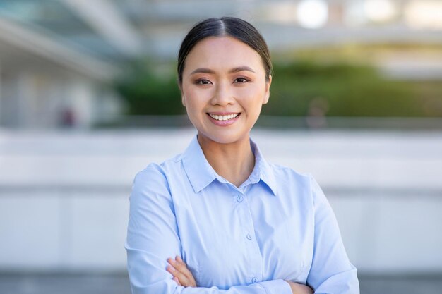 Photo portrait of confident young asian businesswoman standing in urban area