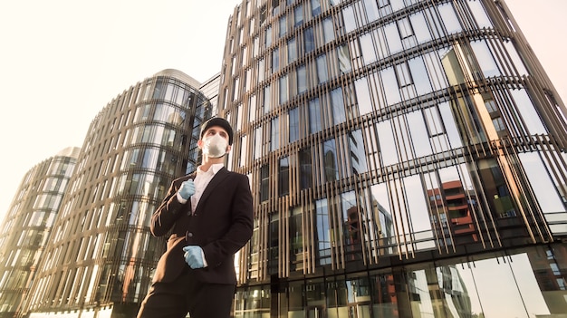 Portrait of confident young businessman in medical mask and rubber gloves