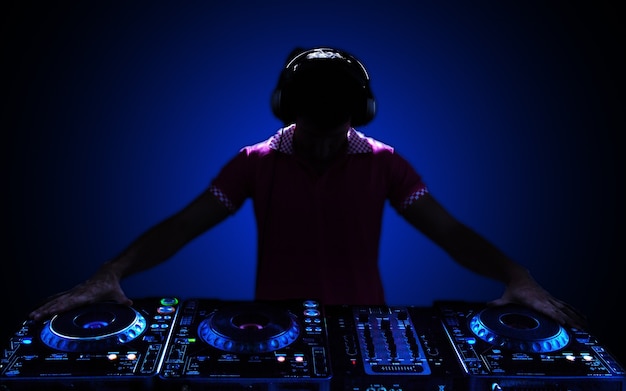 Photo portrait of confident young dj with headphones on head mixing music on mixer