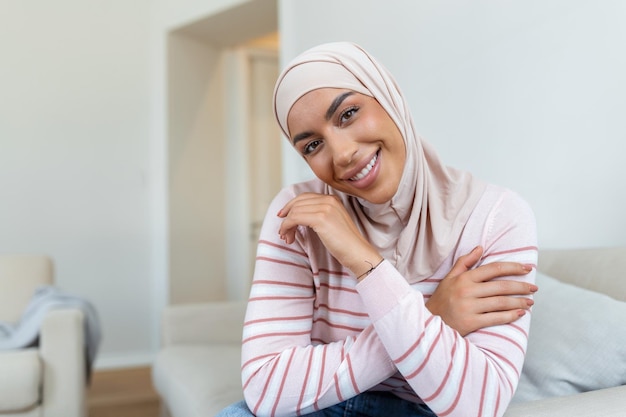 Portrait of confident young Middle Eastern woman with hijab smiling and looking at camera