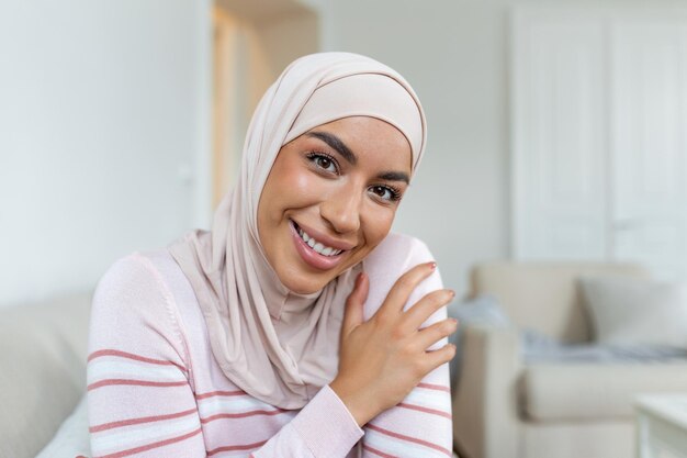 Ritratto di giovane donna mediorientale sicura di sé con l'hijab sorridente e guardando la fotocamera