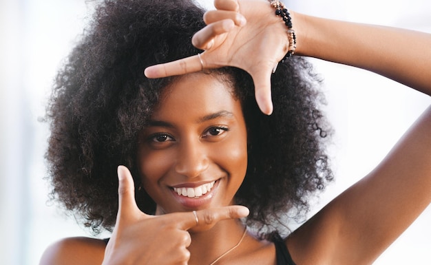 指のフレームを作る自信を持って若い女性の肖像画