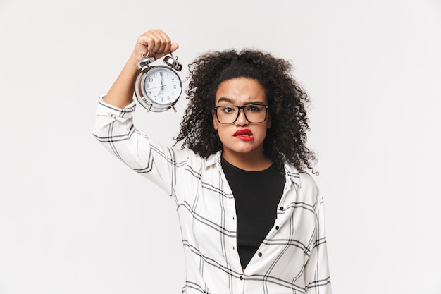 Photo portrait of a confused african woman standing isolated over white background