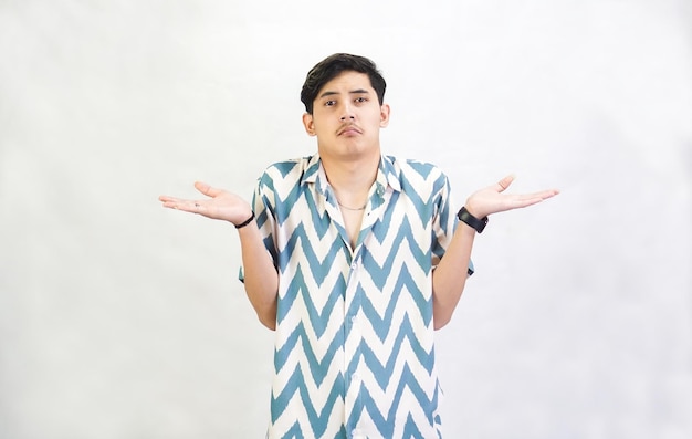 混乱したアジア人男性の肖像画肩をひっくり返し混乱しているか分からないように見えます