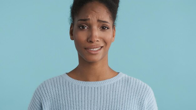 Portrait of confused casual african american girl disappointedly looking in camera over colorful background