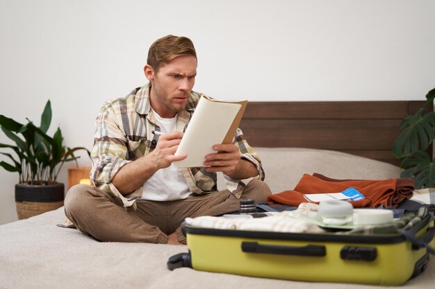 Photo portrait of confused man looks serious at his notes reading something and frowning from disapproval