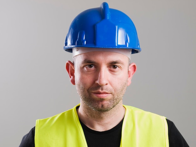 Photo portrait of construction worker against gray background