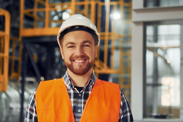 Foto il ritratto dell'operaio edile in uniforme è in fabbrica