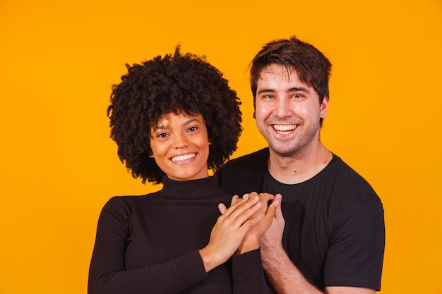 Portrait of content couple in basic clothing smiling at camera
