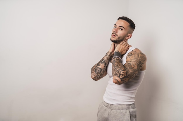 Portrait of a cool sexy tattooed Spanish male posing isolated on a white background