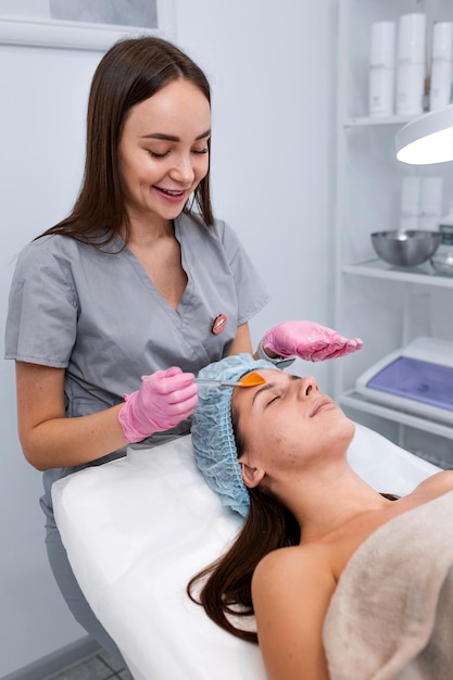 Portrait Cosmetologist applying mask on client's face in spa salon Wellness center Healthcare occupation