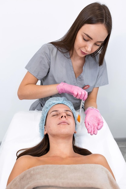 Portrait Cosmetologist applying mask on client's face in spa salon Wellness center Healthcare occupation