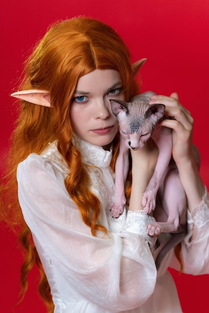 Portrait of cosplay elf young woman in white dress gazing intently at camera with eyes of different ...