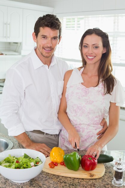 Foto ritratto delle verdure di taglio di una coppia in cucina