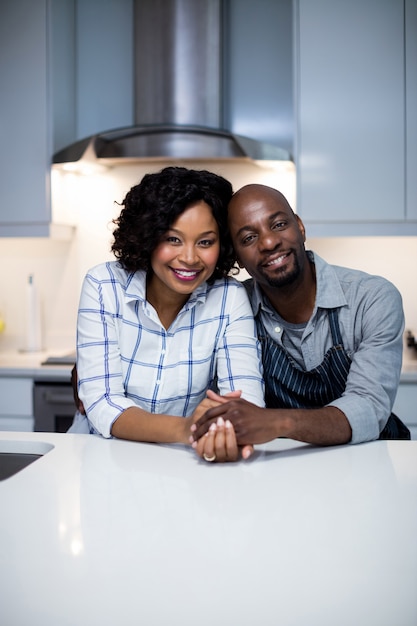 Portrait of couple embracing each other in kitchen