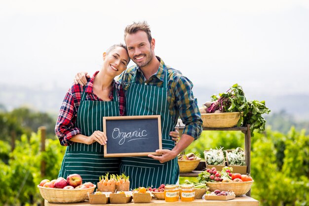 Portrait of couple holding blackboard with text