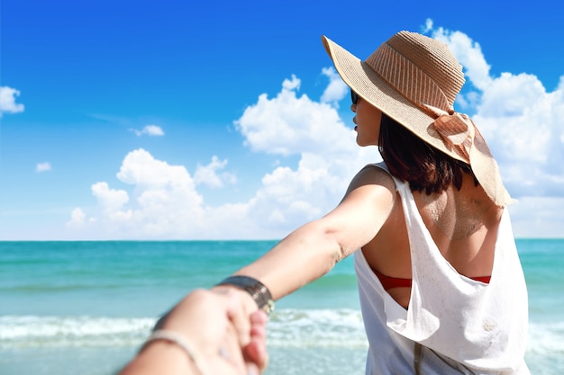 Портрет пары держа руку на пляже с славным голубым небом