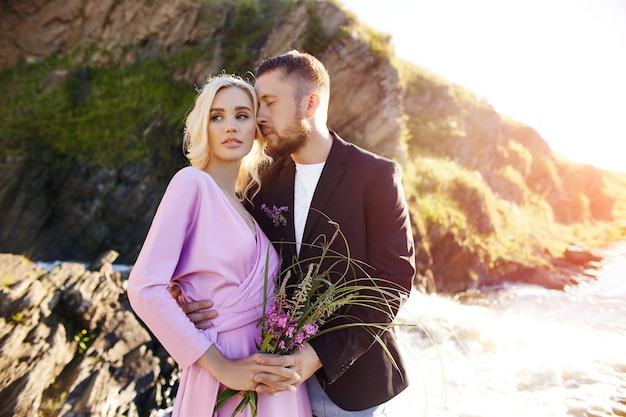 Portrait of a couple in love close-up on a beautiful Sunny day at sunset. Love emotions and hugs in the sun. Blonde woman and man with beard look at each other