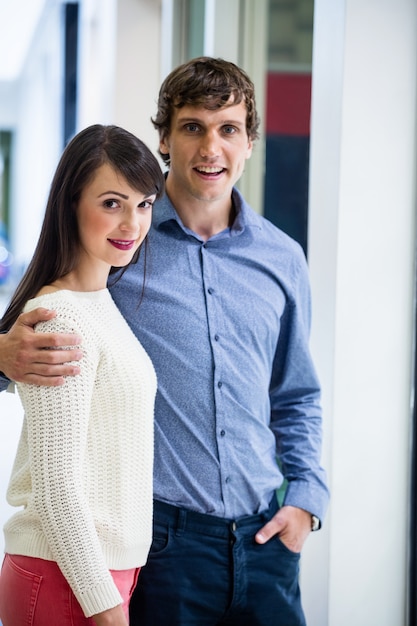 Portrait of couple standing in front of shop 