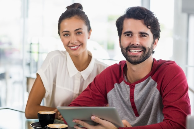 portrait of couple using digital tablet in cafe