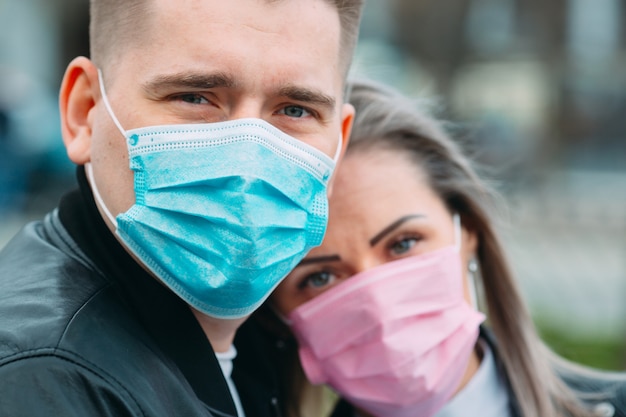 Foto ritratto di una coppia con maschere mediche.