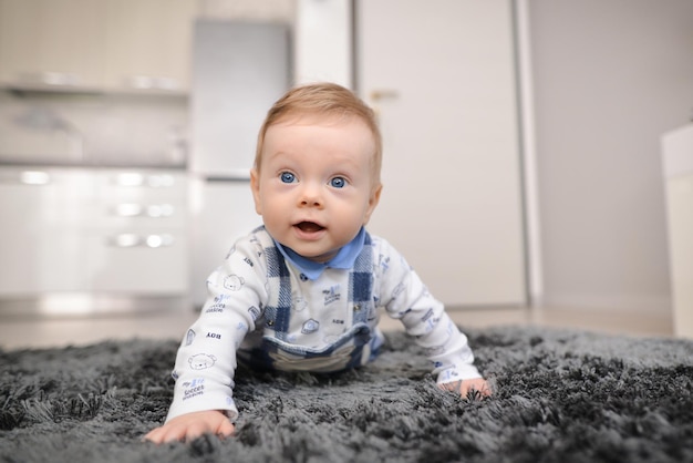 Photo portrait of a crawling baby on the carpet in home smiling crawling baby at home on carpet