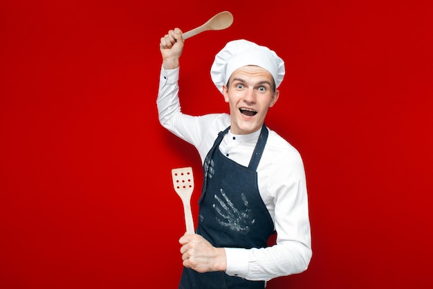 Portrait of a crazy chef on a red isolated background kitchen worker in uniform