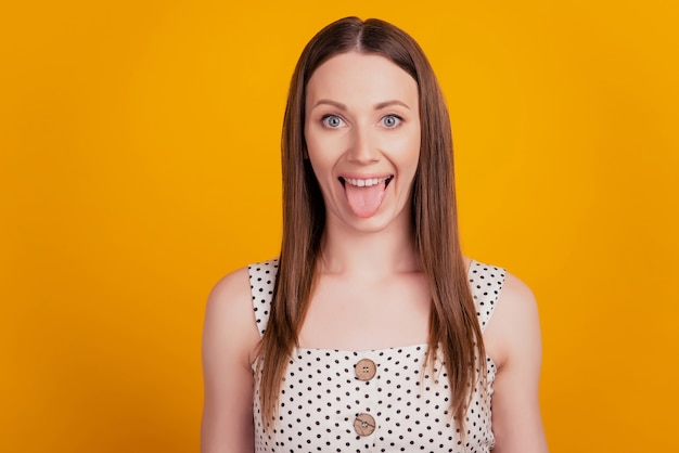 Portrait of crazy funky lady protrude healthy tongue on yellow background