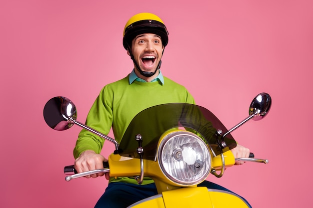 Portrait of crazy overjoyed guy riding motorbike