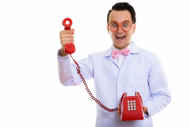 Portrait of crazy young man doctor using old telephone